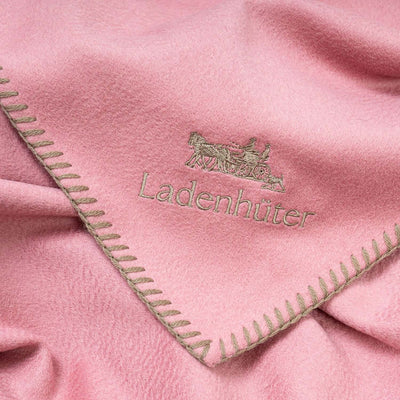 Produktbild rosa Hundedecke aus Kaschmir und Merinowolle mit Logoapplikation und Kettelung. Close-up view.