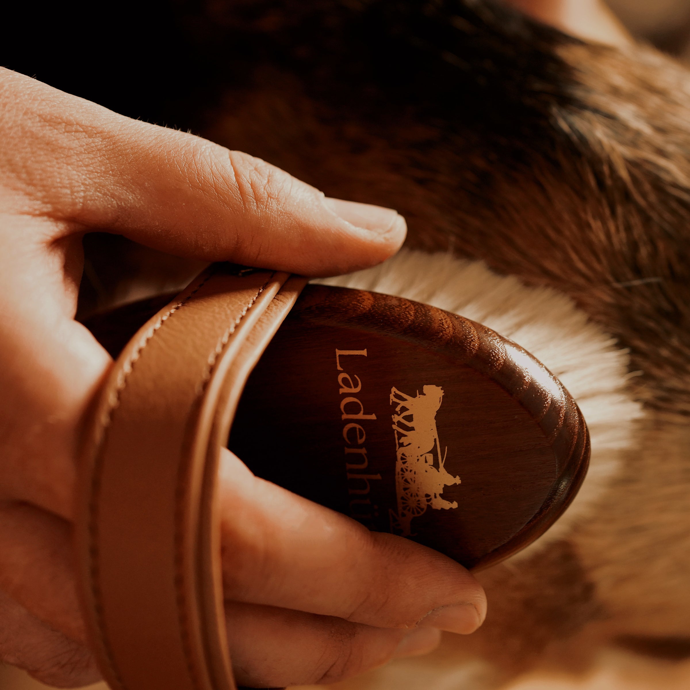 product image showing a man using a beautiful wooden dog brush with real goat hair. 